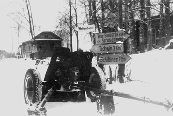 Немецкое орудие рядом с указателем в пригороде Тихвина. Волховский фронт, январь 1942 г.